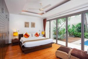 une chambre avec un lit et une grande fenêtre dans l'établissement The Residence Villa 203, à Bang Tao Beach 13 autres photos