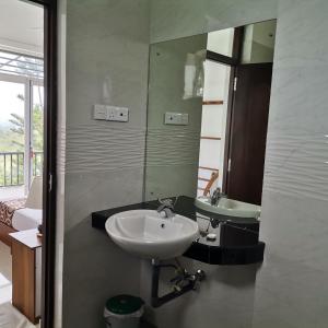 a bathroom with two sinks and a mirror at The Grove in Kandy