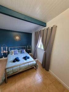um quarto com uma cama com almofadas azuis em Gite 6/8 personnes tout confort em Saint-Martin-des-Besaces