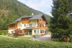 a large house in the middle of a mountain at Familien & Wander-Pension Purkhardt in Donnersbachwald