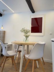 comedor con mesa de madera y sillas blancas en N&E - Home Celanova Rúa Manuel Lezón, en Celanova