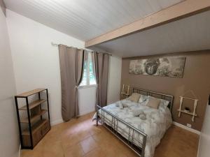 um quarto com uma cama no canto de um quarto em Gite 6/8 personnes tout confort em Saint-Martin-des-Besaces
