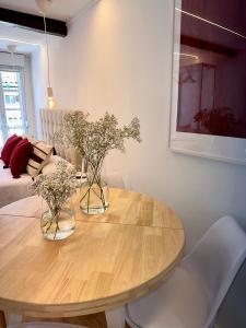 a dining room table with two vases of flowers on it at N&E - Home Celanova Rúa Manuel Lezón in Celanova +4 photos