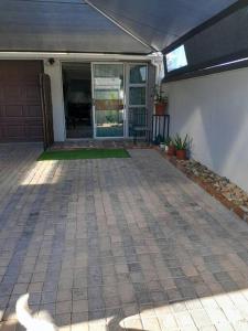 una veranda anteriore di una casa con patio di Magnolia Cottage a Città del Capo