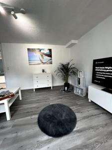 sala de estar con alfombra negra en el suelo en Mittelpunkt der Stadt, en Vellmar