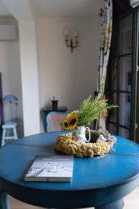 Una mesa azul con un jarrón de flores. en Nomad Rooms, en Mostar