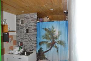 a bathroom with a shower curtain with a palm tree at Studio Canario in El Escobonal