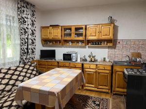 a kitchen with wooden cabinets and a table in it at Casa Danut in Vidra