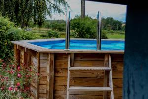 una piscina en una casa de madera con una escalera en Le grivé, en Chèvremont