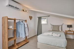 a white bedroom with a bed and a shelf at Sofita Sea View Apartment in Argassi