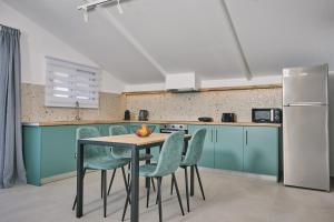 a kitchen with a table and chairs and a refrigerator at Sofita Sea View Apartment in Argassi
