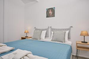 a bedroom with a blue bed with two lamps at Sofita Sea View Apartment in Argassi