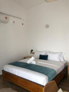 een slaapkamer met een groot bed met witte en blauwe kussens bij Villa Bari Loft in Setiu