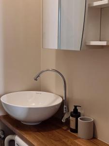 a white sink on a wooden counter in a bathroom at Mo&Ko Snelli Apart - Self Check-in - 5 min from Old Town in Tallinn