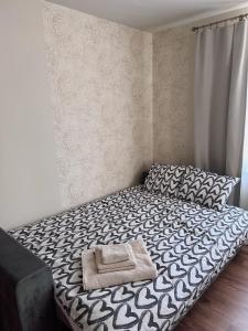 a bedroom with a bed with a black and white comforter at Mo&Ko Snelli Apart - Self Check-in - 5 min from Old Town in Tallinn