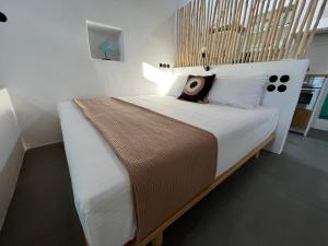 - une chambre avec un grand lit et une tête de lit en bois dans l'établissement White Coral, à Klima