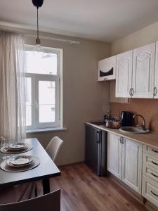 a kitchen with white cabinets and a table and a window at Mo&Ko Snelli Apart - Self Check-in - 5 min from Old Town in Tallinn