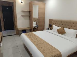 - une chambre avec un grand lit et un miroir dans l'établissement SHRREYAS INN, à Kundapur