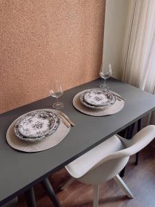 a table with two plates and two glasses on it at Mo&Ko Snelli Apart - Self Check-in - 5 min from Old Town in Tallinn