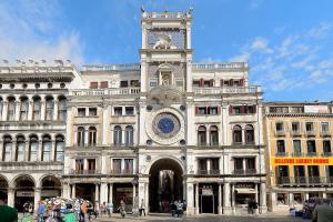 un grand bâtiment avec une tour d'horloge en haut dans l'établissement Bellevue Luxury Rooms - San Marco Luxury, à Venise