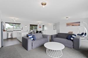 a living room with two couches and a table at Ocean Pearl by Ready Set Stay - BYO LINEN & TOWELS in Surf Beach +10 photos