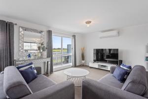 a living room with two couches and a table at Ocean Pearl by Ready Set Stay - BYO LINEN & TOWELS in Surf Beach +12 photos