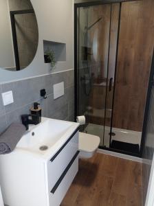 a bathroom with a white sink and a shower at Strefa Kampinos in Brochów
