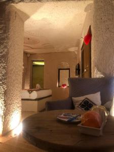 uma sala de estar com uma mesa e um sofá em Corner İn Cappadocia em Ortahisar