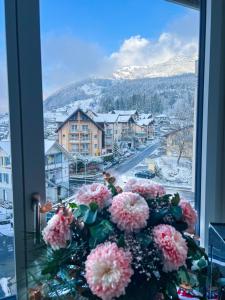 a vase of pink flowers sitting in a window at Suite Room in shared apartment with Mt Rigi View in Goldau