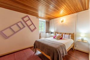 a bedroom with a bed and a wooden ceiling at A Casa da Rapariga de Cabelo Azul in Manteigas