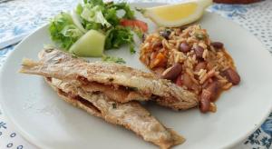 a plate of food with fish and rice and a salad at A Casa da Rapariga de Cabelo Azul in Manteigas