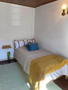 a bed in a room with a blue pillow on it at A Casa da Rapariga de Cabelo Azul in Manteigas