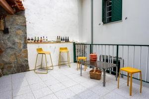 a patio with a table and two stools and a bar at A Casa da Rapariga de Cabelo Azul in Manteigas
