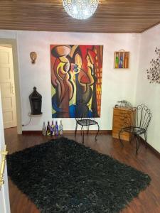 a living room with a large painting on the wall at A Casa da Rapariga de Cabelo Azul in Manteigas