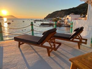 - deux chaises assises sur le côté de la plage dans l'établissement White Coral, à Klima