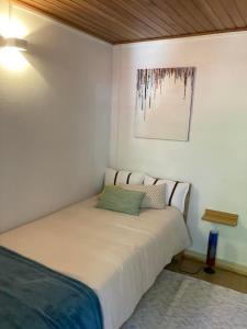 a bedroom with a bed with a picture on the wall at A Casa da Rapariga de Cabelo Azul in Manteigas