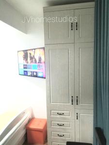 1 dormitorio con armario blanco y TV en JVhomestudios-Ndemi gardens apartments en Nairobi