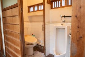 a small bathroom with a toilet and a urinal at うみの図書館 in Sanuki +43 photos