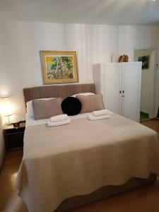 a bedroom with a large bed with two towels on it at Zelena oaza in Baška Voda