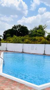 a large blue swimming pool next to a white fence at Ivy Zen 1 BHK with Common Pool 12 kms from Imagicaa in Jambhulpāda