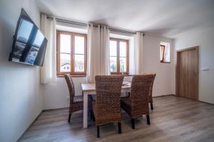 uma sala de jantar com mesa e cadeiras e uma televisão em Promenada Lipno Apartment 123 em Lipno nad Vltavou