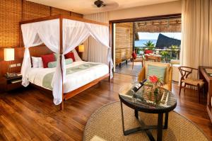 1 dormitorio con 1 cama y 1 mesa en Le Jadis Beach Resort & Wellness - Managed by Banyan Tree Hotels & Resorts en Balaclava