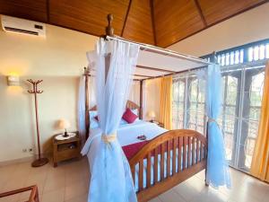 a bedroom with a bed with a canopy at Villa Kinandari Bukit Jimbaran in Jimbaran +22 photos