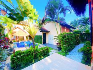 a house with a swimming pool and palm trees at Villa Kinandari Bukit Jimbaran in Jimbaran