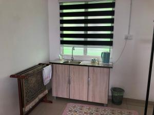 une cuisine avec un évier et une fenêtre dans l'établissement MKB Homestay, à Shah Alam