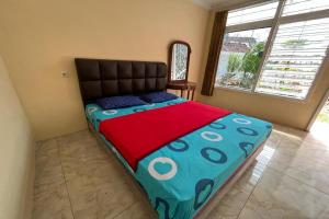 a large bed in a room with a large window at OYO LIFE 92844 Penginapan Cibodas in Pasuruan
