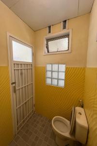 a yellow bathroom with a toilet and a window at OYO LIFE 92844 Penginapan Cibodas in Pasuruan