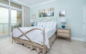 een slaapkamer met een groot bed met witte kussens bij Phoenix Orange Beach II 1105 condo in Orange Beach