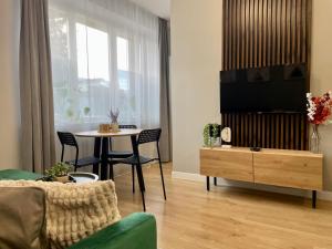 a living room with a table and a tv at Przytulny apartament niedaleko dworca PKP in Radom