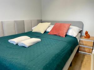 a bed with two pillows on top of it at Przytulny apartament niedaleko dworca PKP in Radom